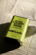 Puszka oliwa extra virgin Versa 1 l na pasiastym lnianym obrusie.