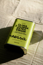 Puszka oliwa extra virgin Versa 1 l na pasiastym lnianym obrusie.